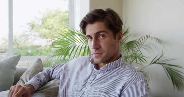 Confident Young Man Relaxing on Couch in Bright Living Room - Download Free Stock Images Pikwizard.com