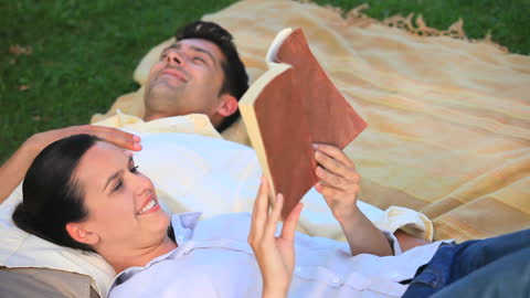 Couple Relaxing with Book in Park