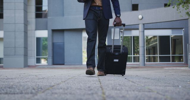 Business professional walking through modern architectural area with a suitcase. Ideal for topics on business travel, corporate lifestyle, and modern professional environments.