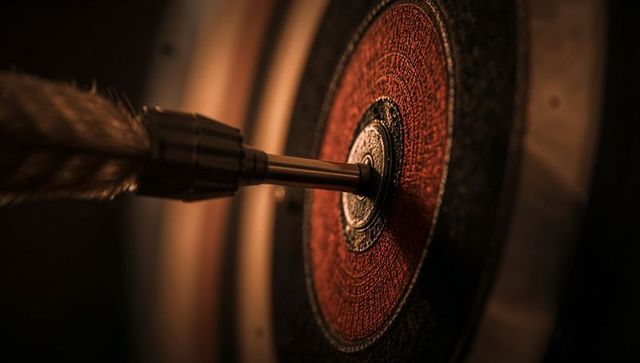 Dart hitting red bullseye on classic dartboard close-up