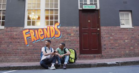 Biracial Friends Conversing on Urban Street with Graffiti - Download Free Stock Images Pikwizard.com