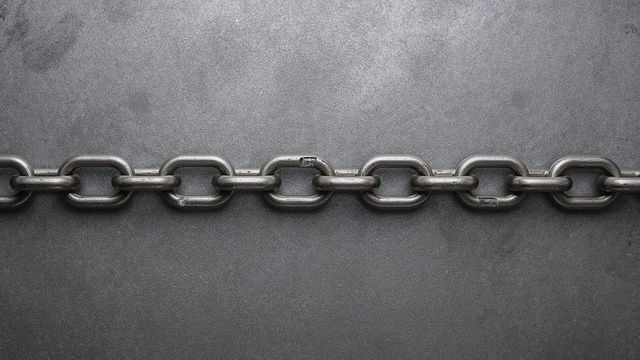 Heavy metal chain across grey workbench displaying strength