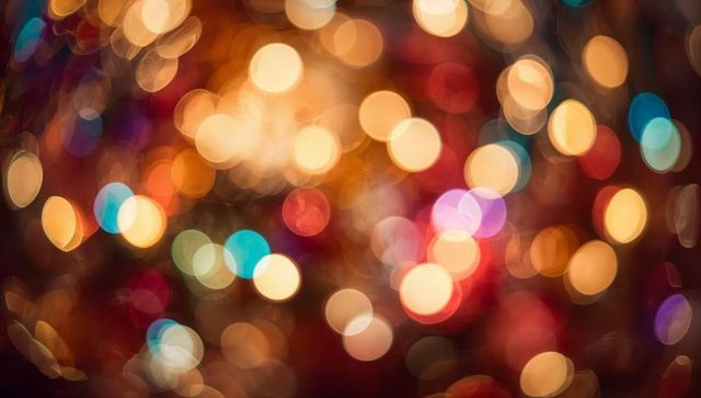 Warm festive bokeh orbs glowing with teal highlights for holiday background use