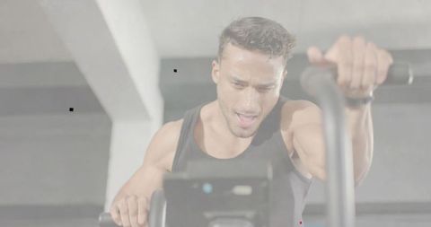 High-intensity stationary bike training with focused man pushing hard in cardio session