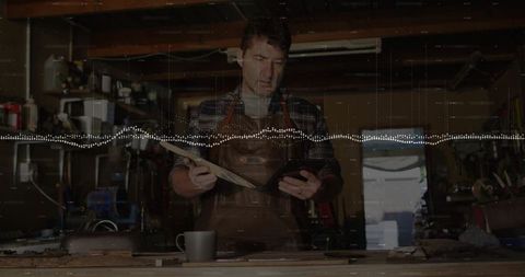 Experienced Carpenter Reviewing Woodwork in Rustic Workshop