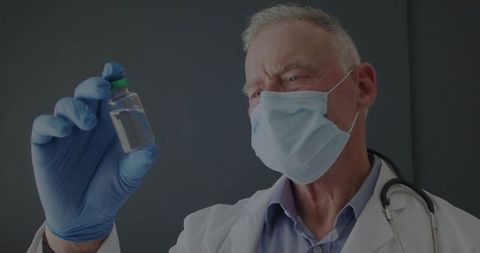 Senior doctor analyzing vial in clinical setting