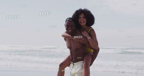 Happy Couple Enjoying Playful Piggyback Ride on Sandy Beach