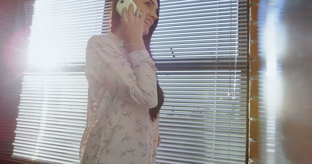 Businesswoman Talking On Smartphone Near Sunlit Window - Download Free Stock Images Pikwizard.com