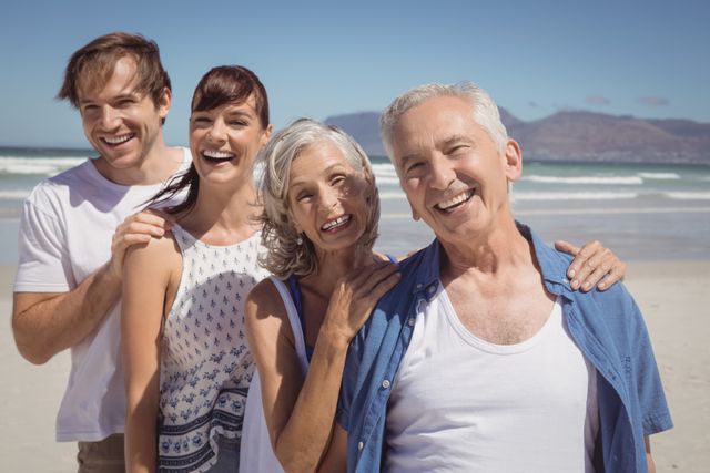 Portrait of happy family standing in row at beach during sunny day