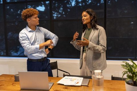 Multiracial colleagues discussing project strategy in modern office meeting