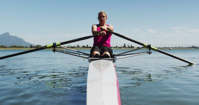 Senior caucasian woman rowing boat on a river. sport retirement leisure hobbies rowing healthy outdoor lifestyle.