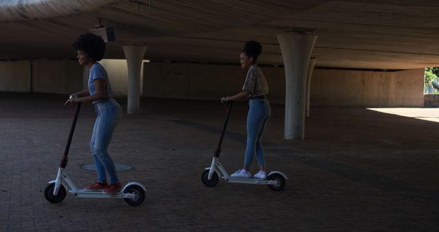 Young women riding electric scooters in urban setting - Download Free Stock Images Pikwizard.com