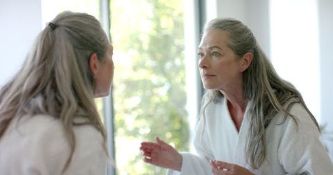 Mature woman interacting thoughtfully in bright living space
