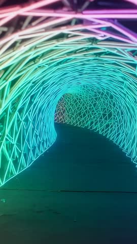 Vertical video advancing through neon-lit lattice tunnel, immersive LED light installation