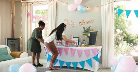 Diverse Friends Prepping Baby Shower Treats in Bright Indoor Space