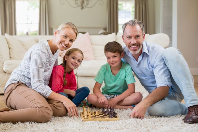 Portrait of family playing chess together at home in the living room at home