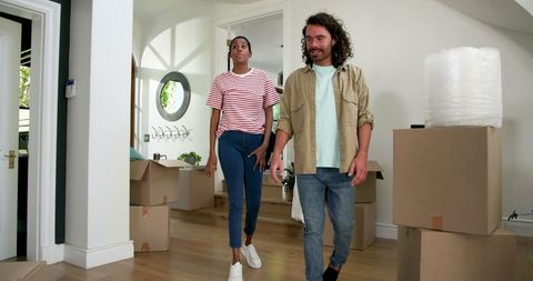 Couple exploring new home surrounded by moving boxes