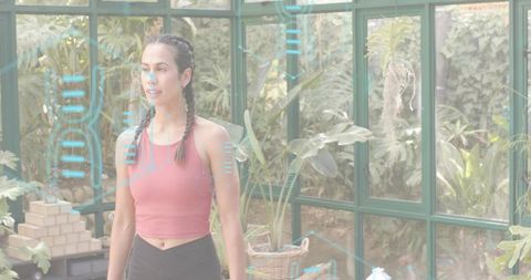 Standing woman stretching in greenhouse wearing activewear with augmented reality fitness overlay