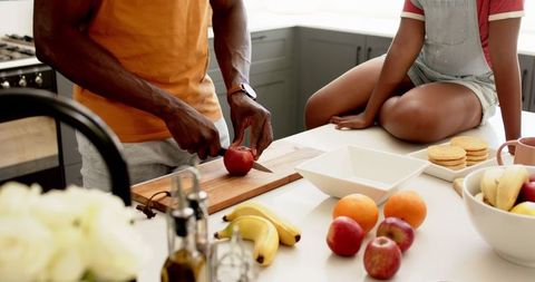 Father and daughter preparing lunch together in kitchen
