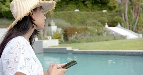 Teenage Girl by Poolside Using Smartphone on Sunny Day