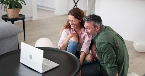Engaged couple video calling sharing joyful news at home