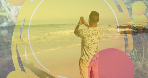 Man Capturing Sunset on Tropical Beach