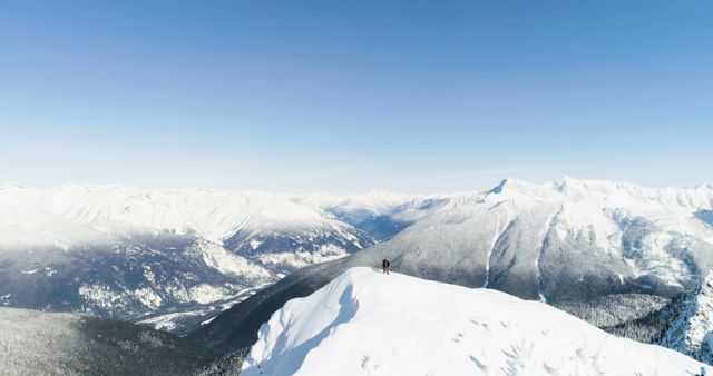 A lone hiker stands atop a snowy mountain ridge, outdoor - Download Free Stock Photos Pikwizard.com