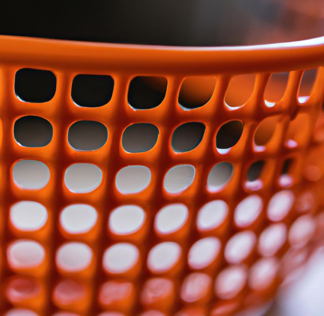 Image of close up of orange traditional plastic basket on grey background. Orange fruit and colour concept.