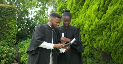 Joyful Graduation Selfie with Diplomas Outdoors
