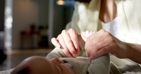 Mother bonding with infant daughter on cozy rug