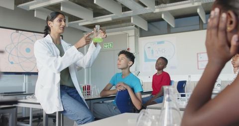 Science teacher demonstrating chemistry to attentive students