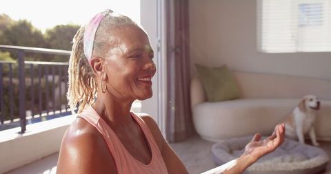 Joyful Senior Woman Meditating at Home with Calming Light