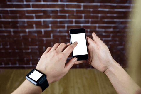 Hands using smartphone in front of transparent bricks background