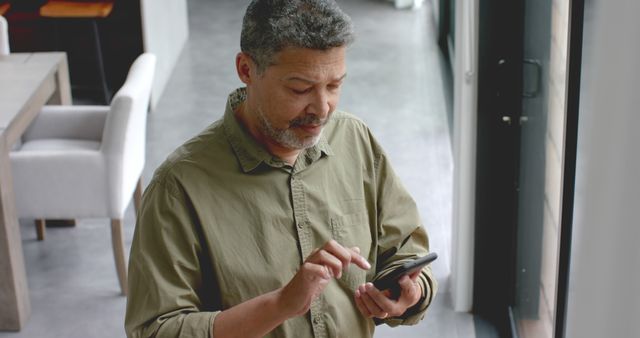 Middle-aged Man Focusing on Smartphone by Large Window - Download Free Stock Images Pikwizard.com