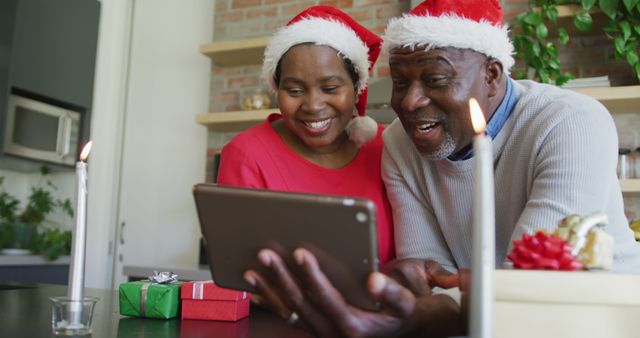 Senior couple enjoying a video call with family during the Christmas holiday season. Ideal for promoting holiday technology use, virtual family gatherings, festive season advertisements, and elder joy during winter celebrations.