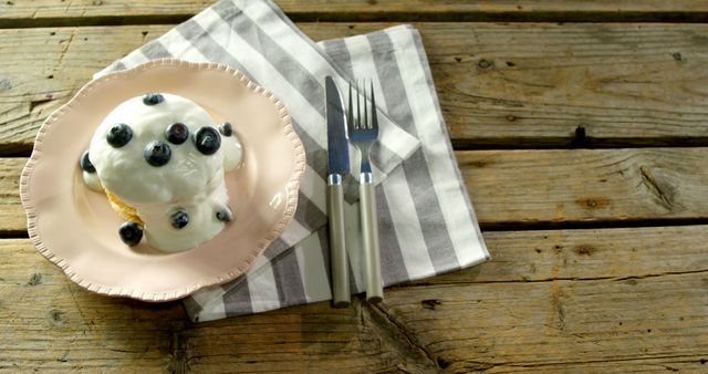 A homemade blueberry tart with whipped cream is served on a rustic table, inviting indulgence. - Download Free Stock Photos Pikwizard.com