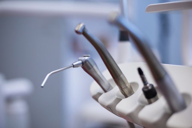Close-up view of dental tools and equipment in a dental clinic. Ideal for use in articles, blogs, and websites related to dental care, dentistry, dental hygiene, and healthcare. Can be used for educational materials, dental practice promotions, and medical tool advertisements.