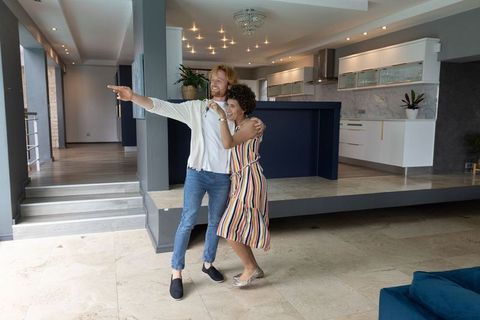 Diverse couple embracing in luxurious open-plan home