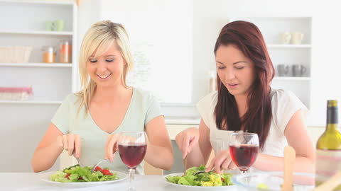 Friends Enjoying Salad and Red Wine in Bright Kitchen