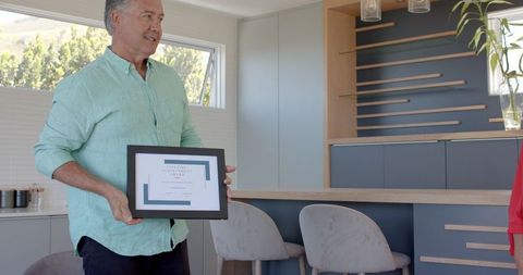 Senior Couple Laughing Together in Bright Kitchen