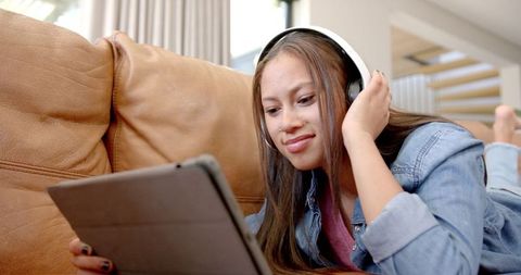 Young Woman Enjoying Music and Browsing Tablet