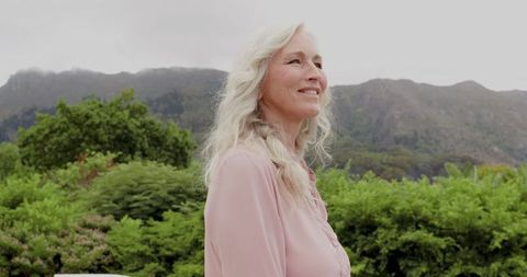 Serene Elderly Woman Enjoying Tranquil Mountain Landscape