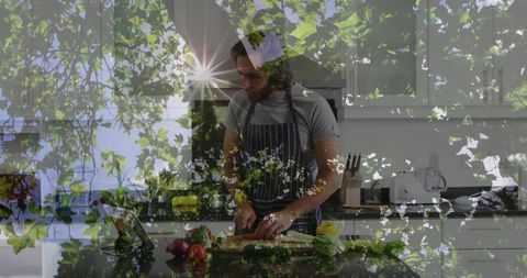 Man prepares fresh vegetables in modern kitchen with greenery overlay
