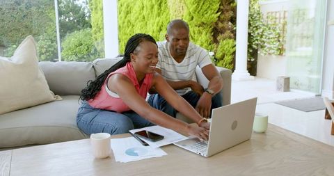 Couple Managing Finances Together on Laptop in Living Room