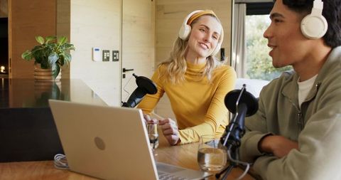 Couple Recording Podcast in Home Kitchen with Laptop, Headphones and Professional Microphones