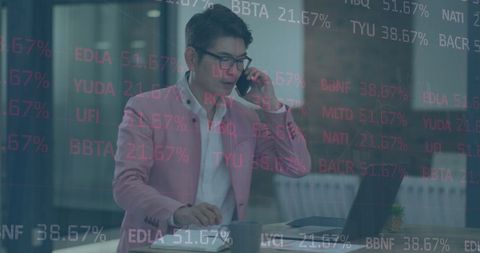 Asian Businessman Analyzing Stock Market Data in Office