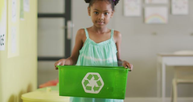 Image of happy african american girl holding box with recycling symbol in classroom - Download Free Stock Photos Pikwizard.com