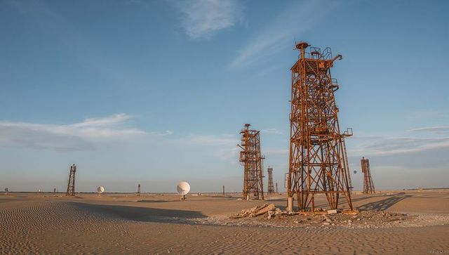 Rusty towers in vast desert with communication equipment