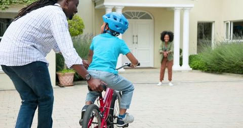 Father Teaching Son to Ride Bike Mom Encouraging