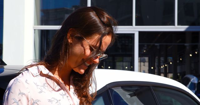 Smiling Woman in Sunglasses Standing by Car in Urban Setting - Download Free Stock Images Pikwizard.com